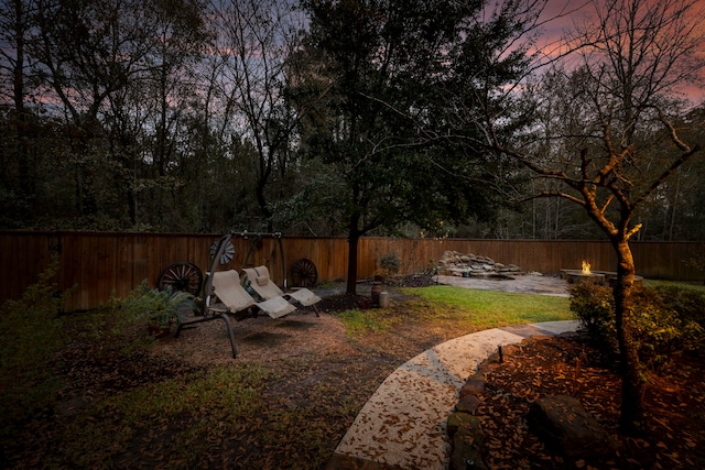 yard at dusk featuring an outdoor fire pit