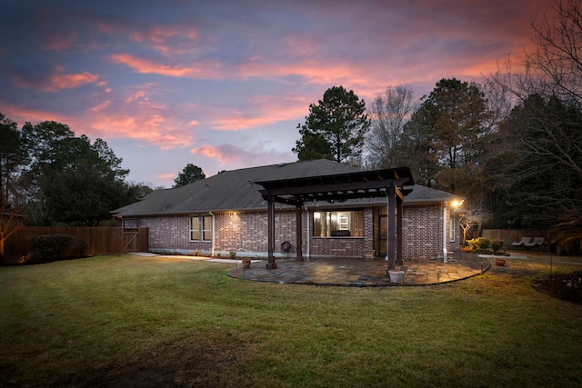 back house at dusk featuring a patio, a yard, and a pergola