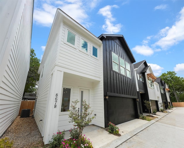 view of property featuring central AC unit and a garage