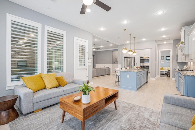 living room featuring ceiling fan and sink