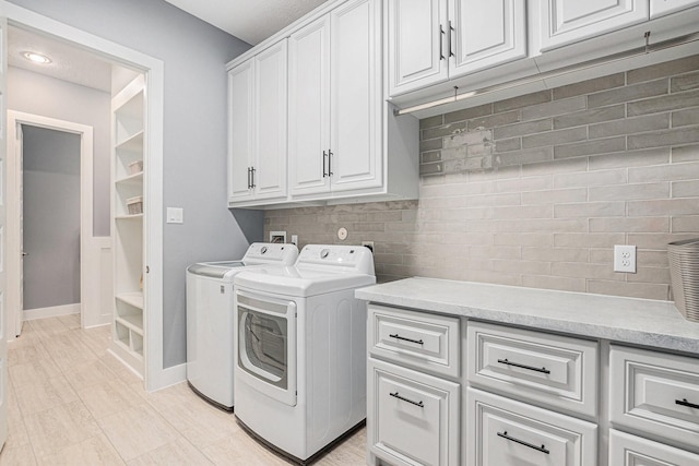 laundry room featuring cabinets and washer and clothes dryer