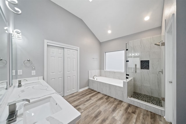 bathroom with vanity, hardwood / wood-style flooring, vaulted ceiling, and independent shower and bath