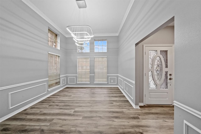 foyer entrance with a notable chandelier, hardwood / wood-style flooring, and plenty of natural light