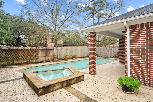 view of pool with a patio and an in ground hot tub