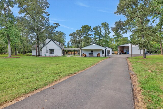 view of front facade with a garage, an outdoor structure, and a front yard