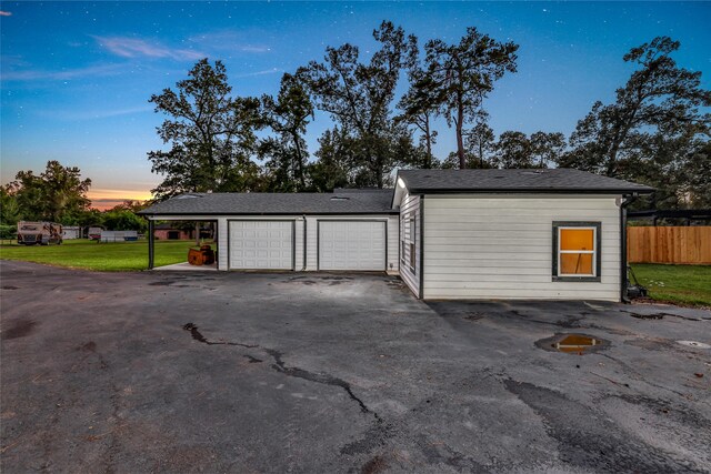 garage at dusk with a yard