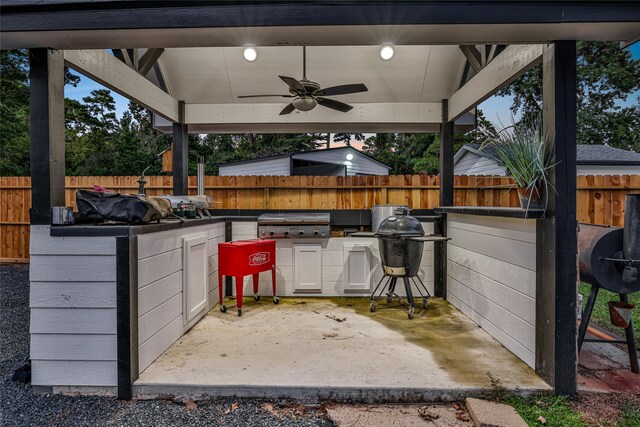 view of patio / terrace featuring ceiling fan, an outdoor kitchen, and a grill