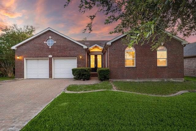 view of front of home featuring a garage, a yard, and french doors