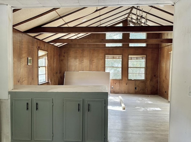 interior space with lofted ceiling with beams, wooden walls, and light hardwood / wood-style floors