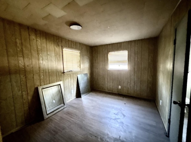 spare room featuring hardwood / wood-style floors and wooden walls