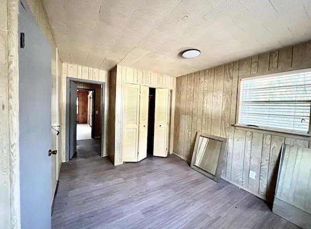 unfurnished room featuring dark hardwood / wood-style floors and wood walls