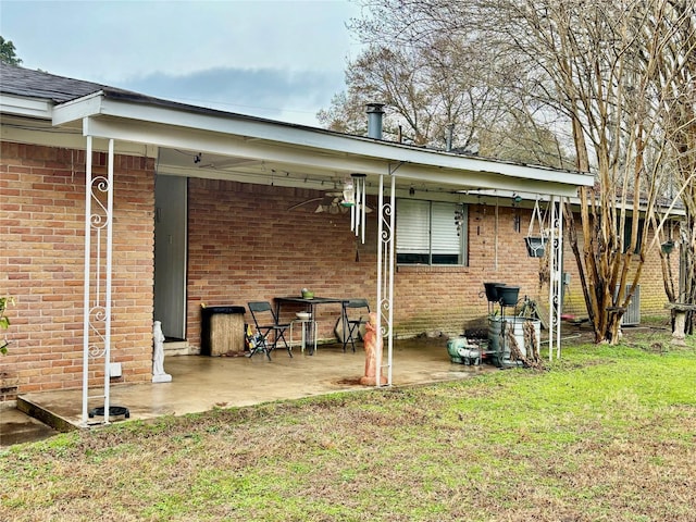 back of property featuring ceiling fan, a patio area, and a lawn