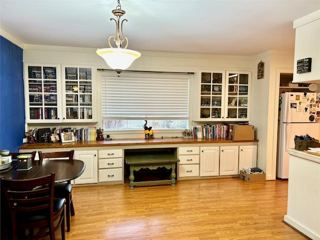 kitchen with white refrigerator, wooden counters, decorative light fixtures, and light hardwood / wood-style flooring