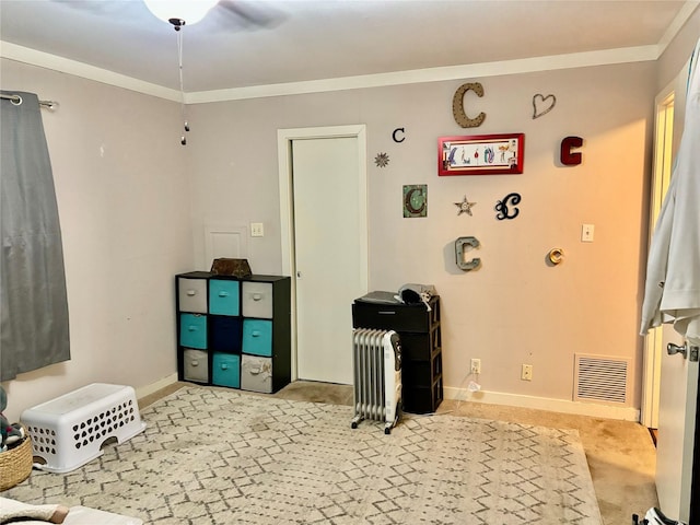 playroom with ornamental molding, radiator, and light carpet