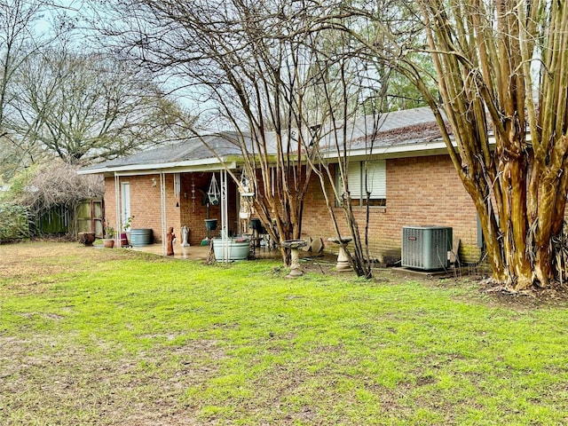 back of property with a yard and central AC