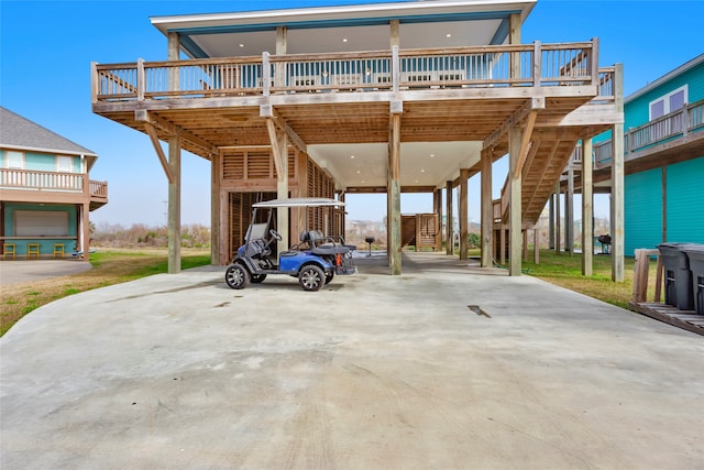 exterior space with a carport, concrete driveway, and stairs