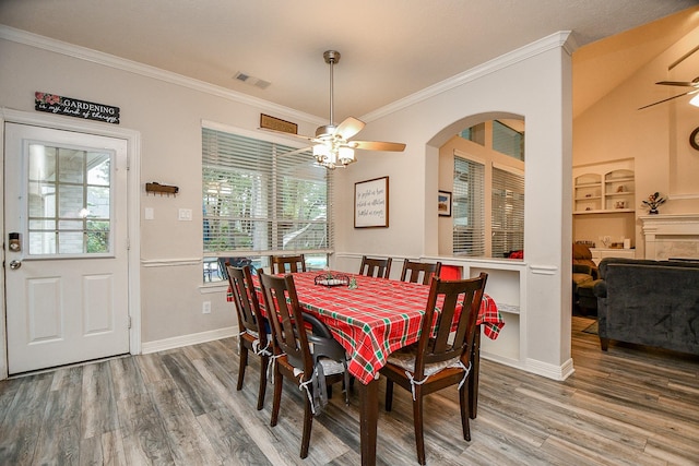 dining area with hardwood / wood-style flooring, ceiling fan, ornamental molding, and built in features