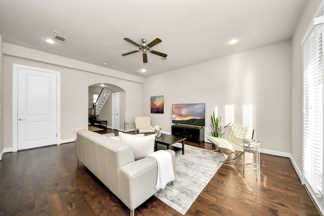 living room featuring dark wood-type flooring and ceiling fan