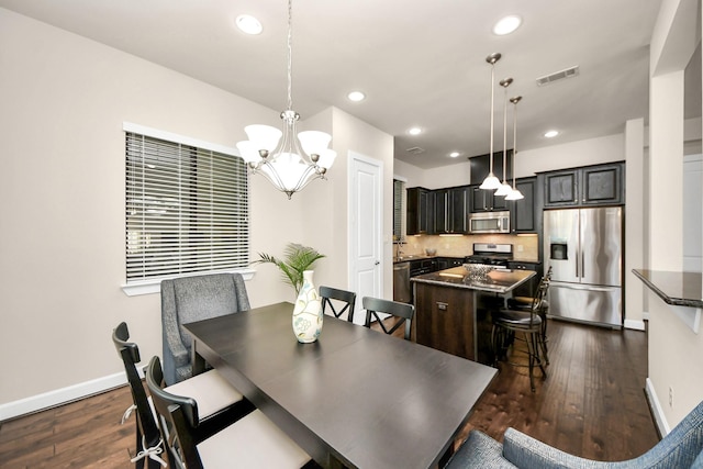 dining area with dark hardwood / wood-style flooring and a notable chandelier