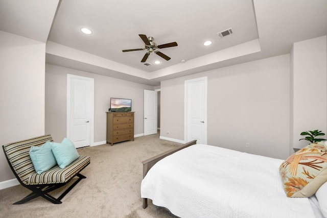 bedroom with carpet floors, a raised ceiling, and ceiling fan