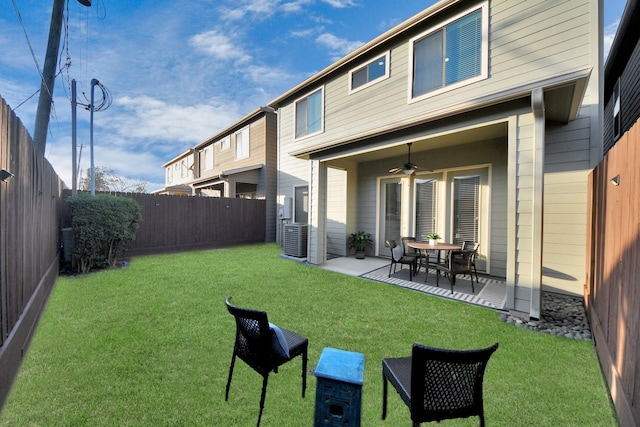 rear view of property featuring a patio, a yard, central AC unit, and ceiling fan