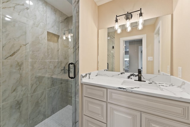 bathroom with vanity and a marble finish shower