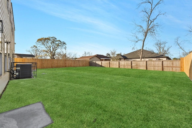 view of yard with central air condition unit and a fenced backyard