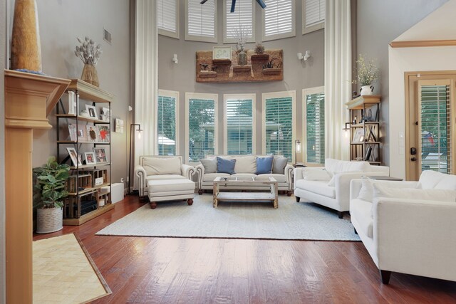 living room with dark hardwood / wood-style floors and a high ceiling