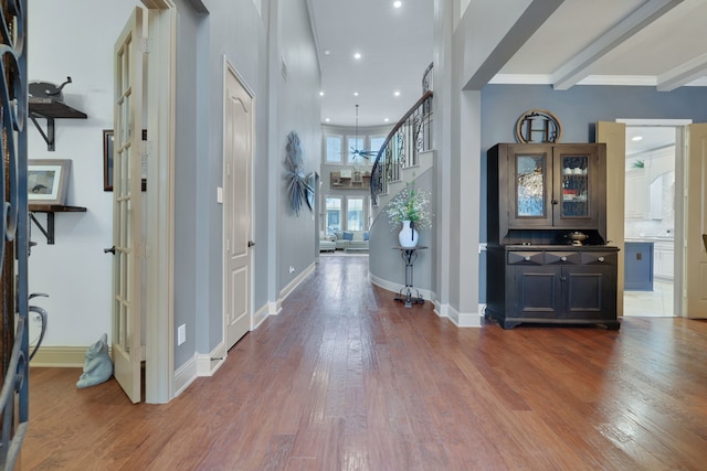 entryway with recessed lighting, wood finished floors, baseboards, stairs, and beamed ceiling