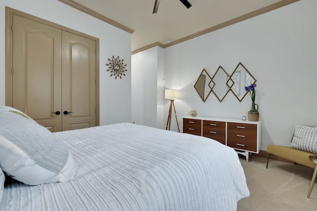 bedroom featuring light carpet, a closet, a ceiling fan, and crown molding