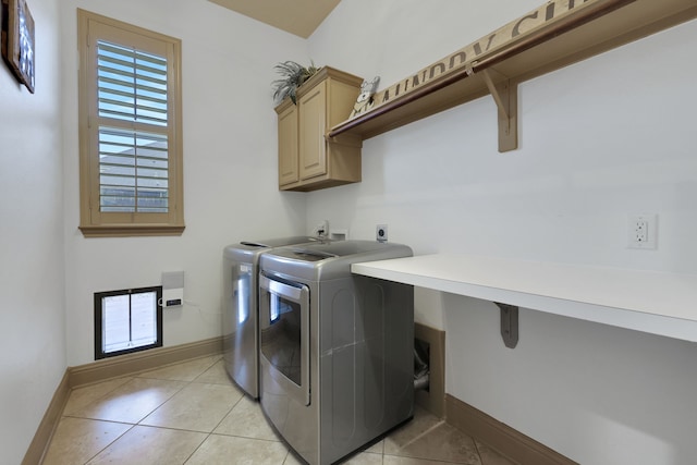 laundry area featuring a healthy amount of sunlight, cabinet space, washer and clothes dryer, and light tile patterned floors