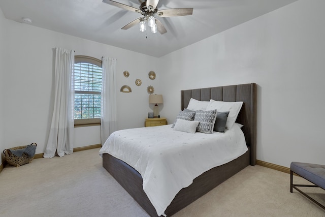 carpeted bedroom with ceiling fan and baseboards