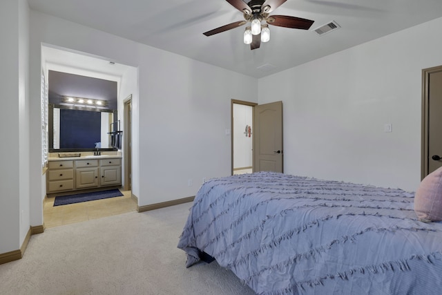 bedroom with light colored carpet, visible vents, ensuite bath, and baseboards