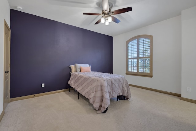 bedroom with light colored carpet, ceiling fan, and baseboards