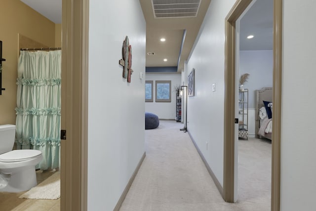 hall featuring light carpet, baseboards, visible vents, and recessed lighting