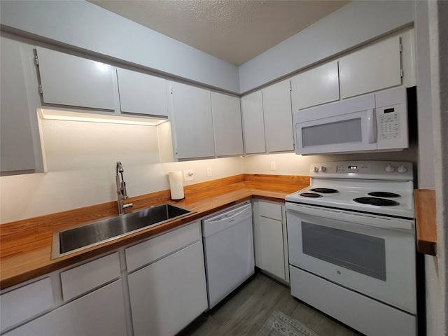 kitchen with white cabinetry, sink, a textured ceiling, and white appliances