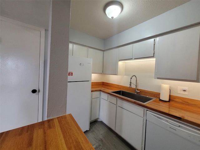 kitchen featuring white cabinetry, sink, white appliances, and butcher block counters