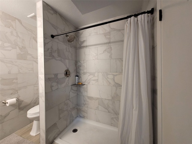 bathroom featuring walk in shower and toilet