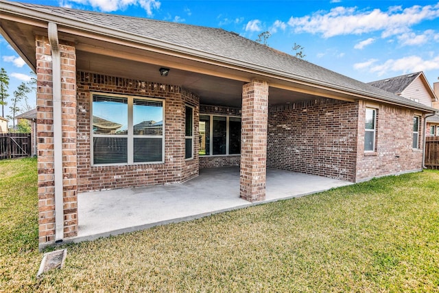 rear view of property with a yard and a patio area