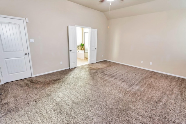 carpeted spare room featuring lofted ceiling and ceiling fan