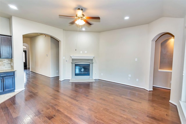 unfurnished living room featuring ceiling fan and dark hardwood / wood-style flooring