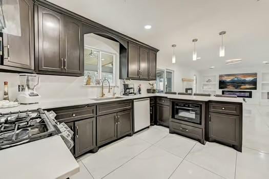 kitchen featuring decorative light fixtures, dishwasher, sink, dark brown cabinetry, and kitchen peninsula