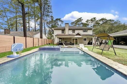 back of house with a fenced in pool and pool water feature