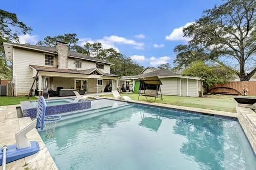 rear view of house featuring a patio, a lawn, and a pool with hot tub