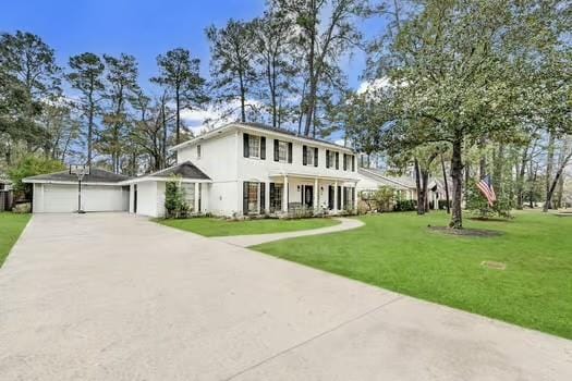 view of front of home with a garage, a front lawn, and covered porch