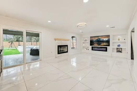 unfurnished living room with built in shelves