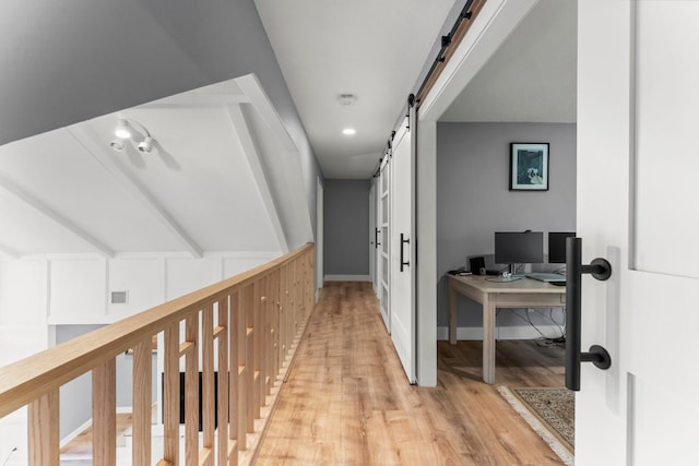 hall featuring a barn door and light wood-type flooring