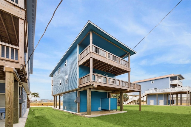 rear view of house with a lawn and a balcony