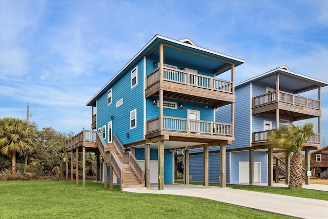 rear view of house with a carport, a balcony, a garage, and a lawn