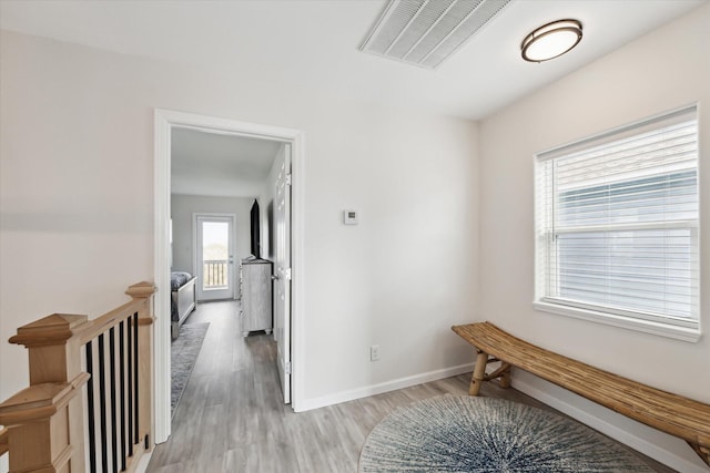 hallway with light hardwood / wood-style floors